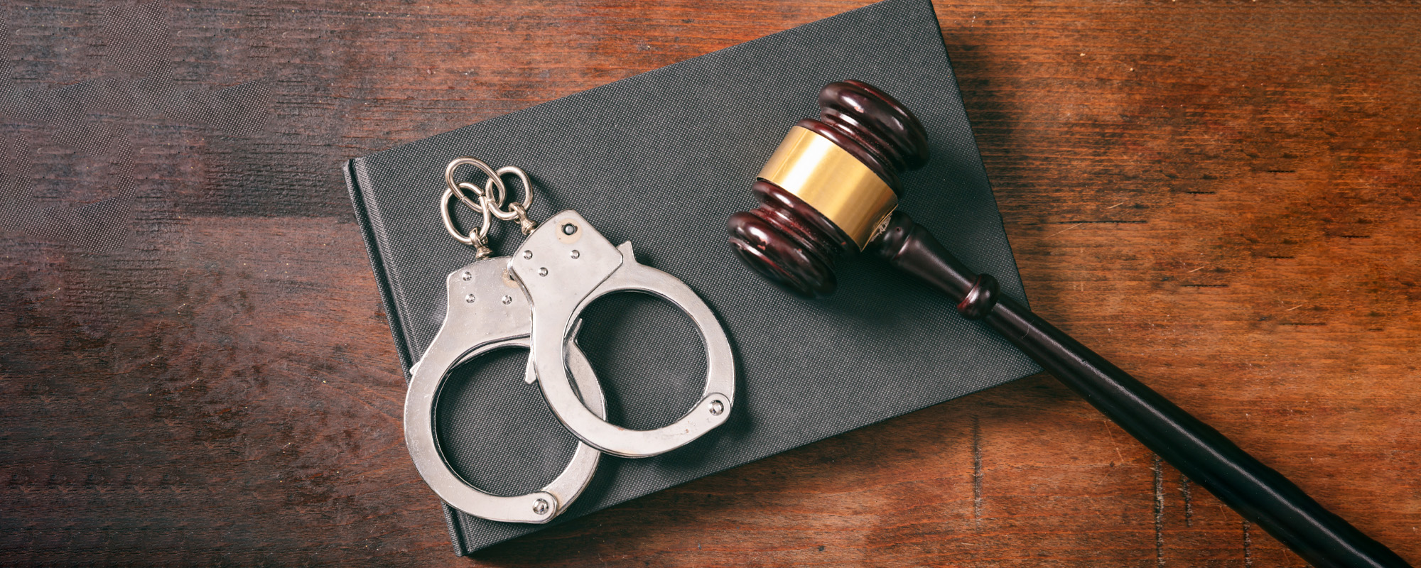 handcuffs gavel on book on a wooden background
